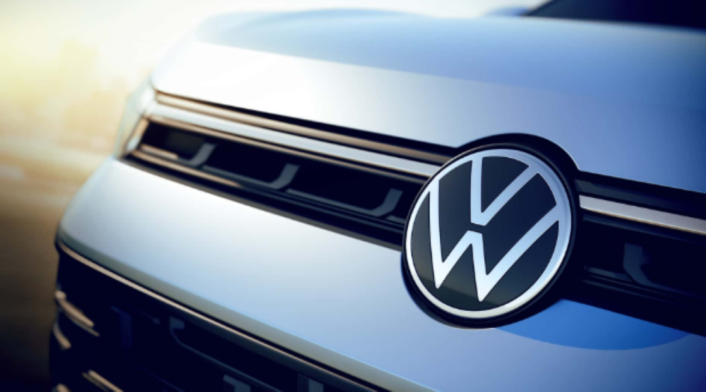Volkswagen anuncia oportunidades de emprego no Brasil Logo da Volkswagen destacada na grade frontal de veículo em fundo desfocado